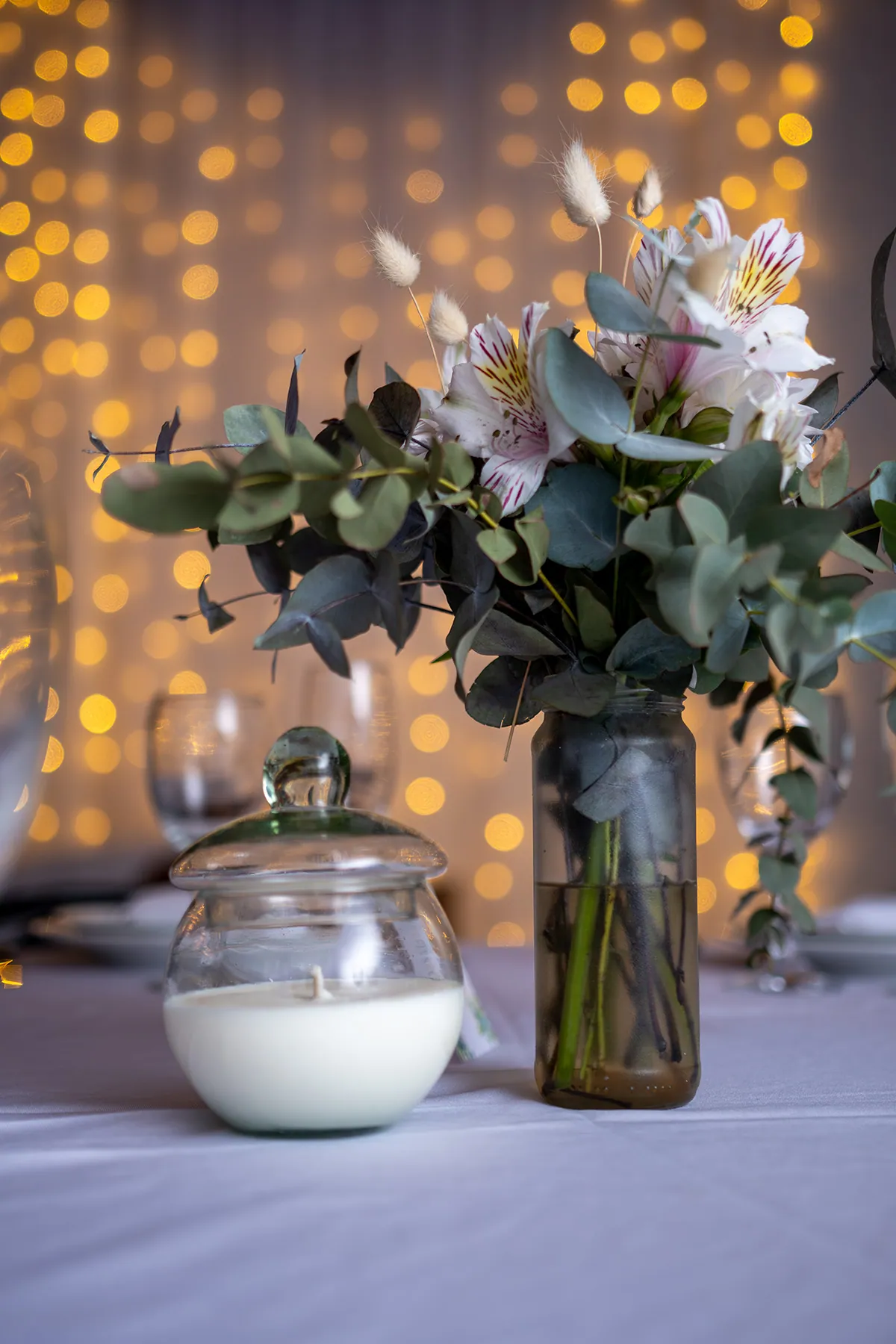 Detalle del centro de mesa con vela y flores en la recepción