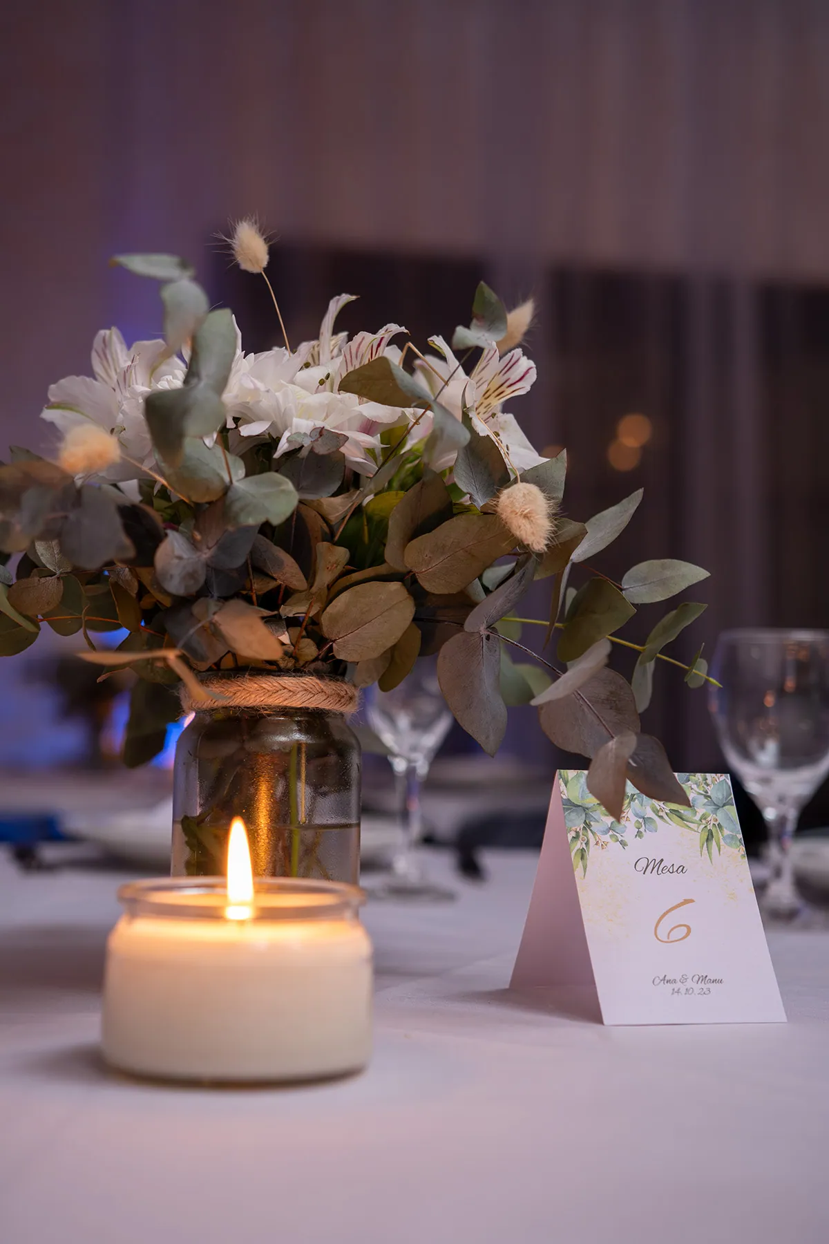 Tarjeta de mesa con la fecha del casamiento, junto a una vela encendida