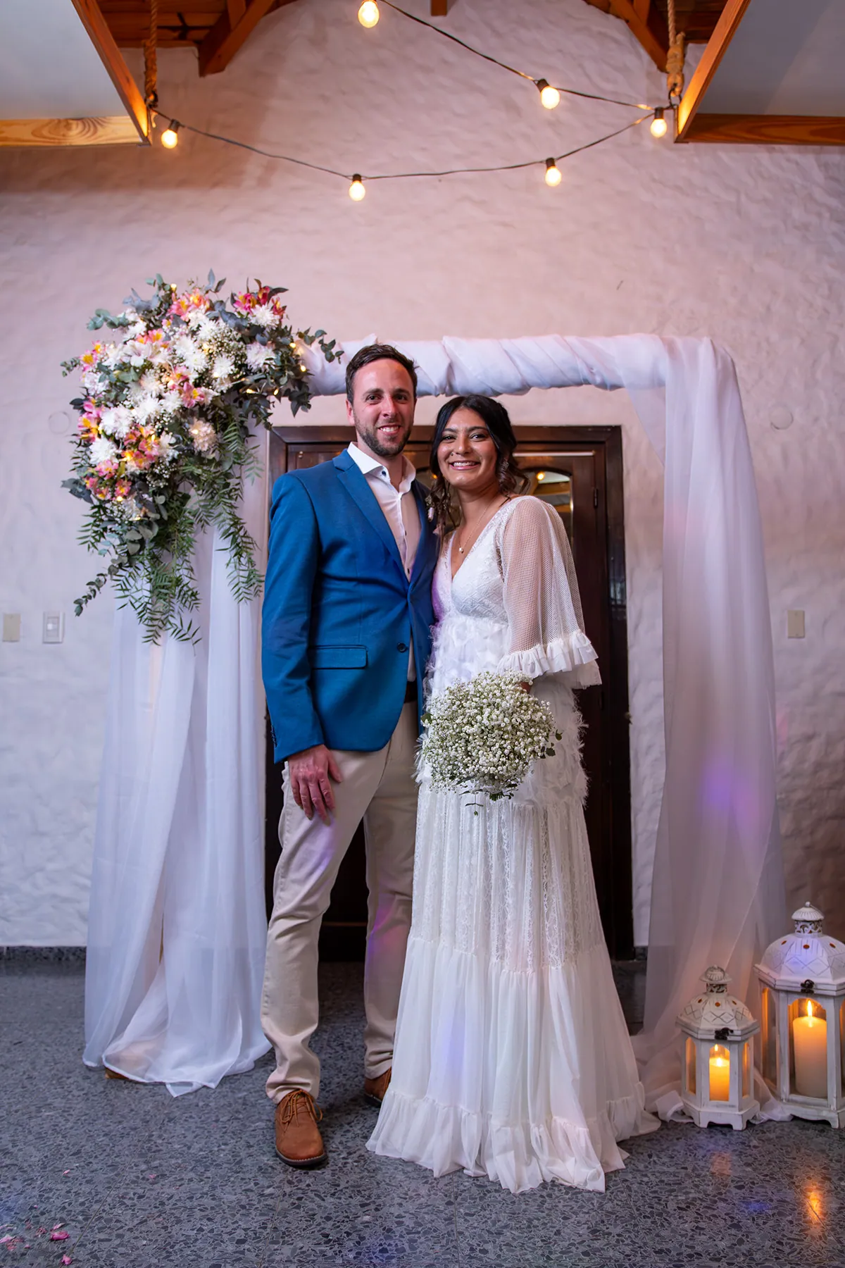 Retrato de los novios bajo el arco de flores del salón